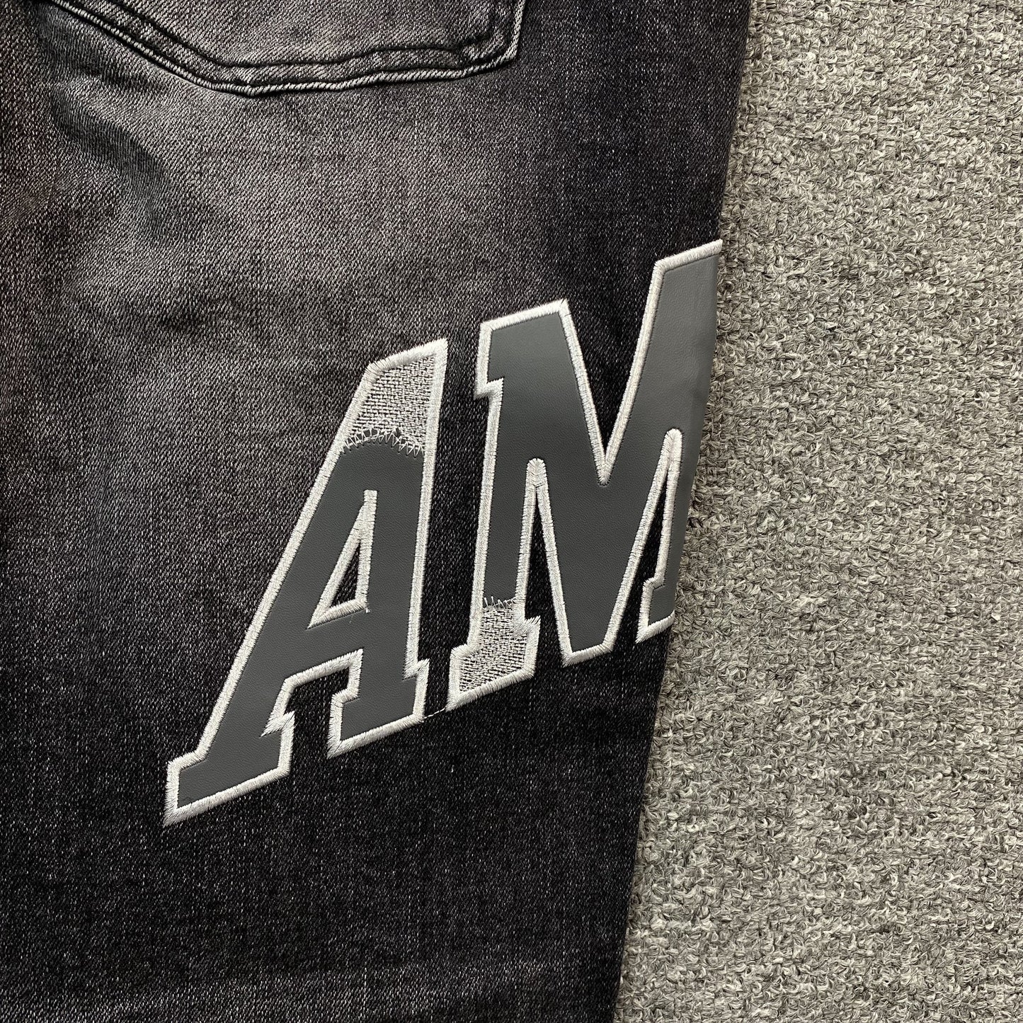 AMIRI VARSITY LOGO REPAIR JEANS